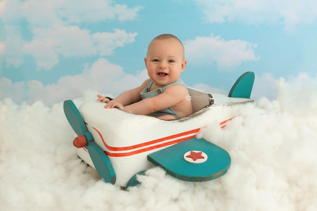 reportajes de bebés en Bilbao, Barakaldo. Foto de bebé en un fondo cielo con avion